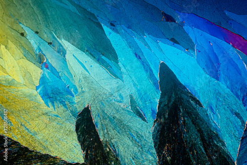 Polarized light microscopy reveals the cool blue and warm yellow hues of erythritol sugar crystals with detailed textures photo