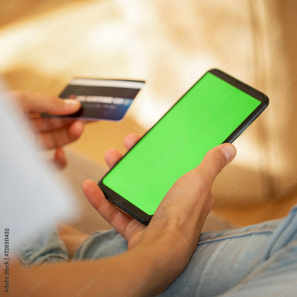 Close up of smartphone with green screen and bank card in female hands. Online shopping or payment. Close up of smartphone with green screen and bank card in female hands. Online shopping or payment.