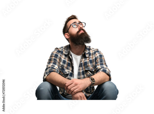 An isolated bearded man in casual wear sits with hands on his thighs and looks up photo