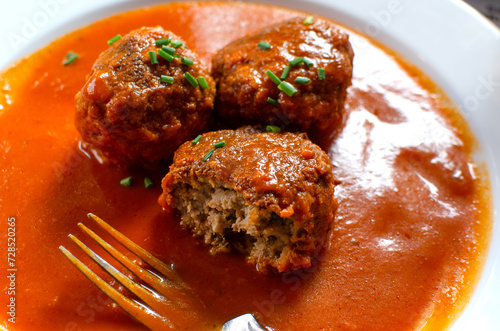 Le boulet  with tomato sauce with pieses of bunching onio non top
