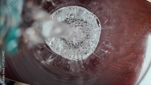 Slow motion pouring of mineral water on a glass close pu photo