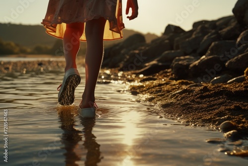 A person standing in the water with their feet submerged. This image can be used to depict relaxation, summer activities, or enjoying nature by the water