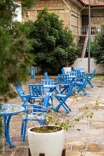 Atmospheric summer photography. Wooden tables decorated with blue napkins. Open street cafe in a marine style