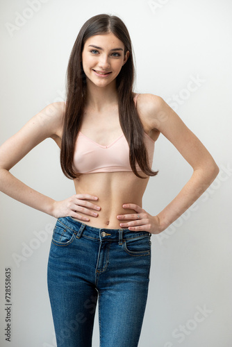 Beautiful young smiling woman wearing jeans and bra