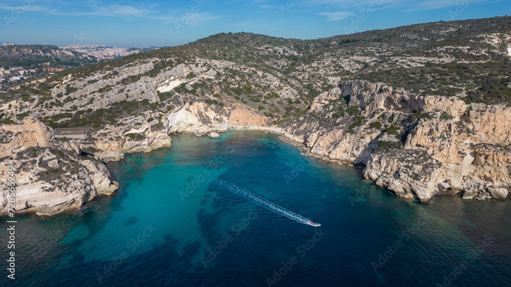 Aerial view with drone of the Sella del Diavolo in Cagliari. Sunny day, crystal clear sea with boats. Aerial view with drone of the Sella del Diavolo in Cagliari. Sunny day, crystal clear sea with boats.