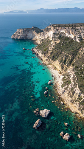Aerial view with drone of the Sella del Diavolo in Cagliari. Sunny day, crystal clear sea with boats.