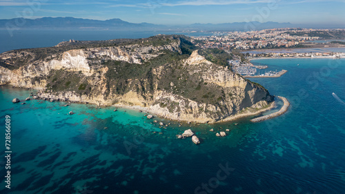 Aerial view with drone of the Sella del Diavolo in Cagliari. Sunny day, crystal clear sea with boats.