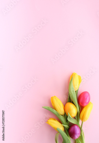 A Vibrant Easter Bouquet  Yellow Tulips and Colorful Eggs on a Soft Pink Background
