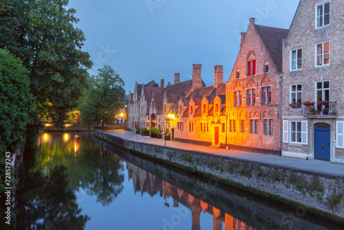 Scenic cityscape with a medieval tower Belfort and the Green canal, Groenerei, at sunset in Bruges, Belgium