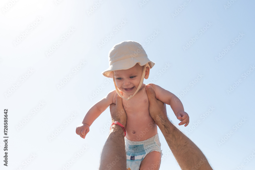 Sun-kissed moments of a father holding his infant high. Concept of paternal warmth and childhood glee Sun-kissed moments of a father holding his infant high. Concept of paternal warmth and childhood glee
