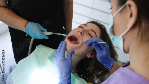 Close-up of the hands of a dentist doing oral examination with mirror photo