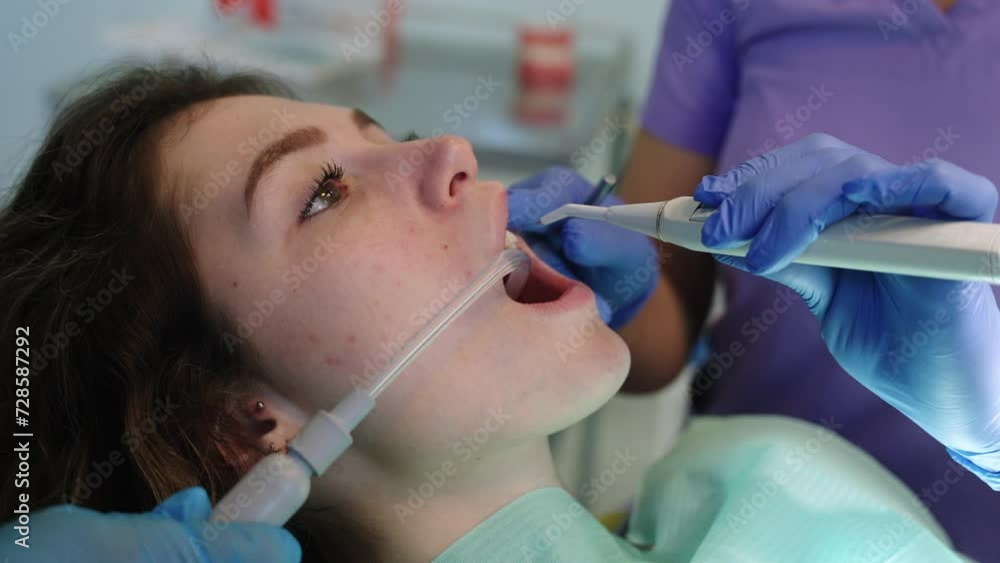 Dentist cleaning teeth of a young woman Dentist cleaning teeth of a young woman