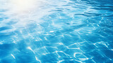 Blue water surface with bright sun light reflections water in swimming pool background closeup 