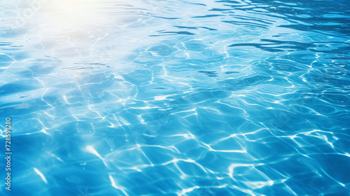 Blue water surface with bright sun light reflections water in swimming pool background closeup 