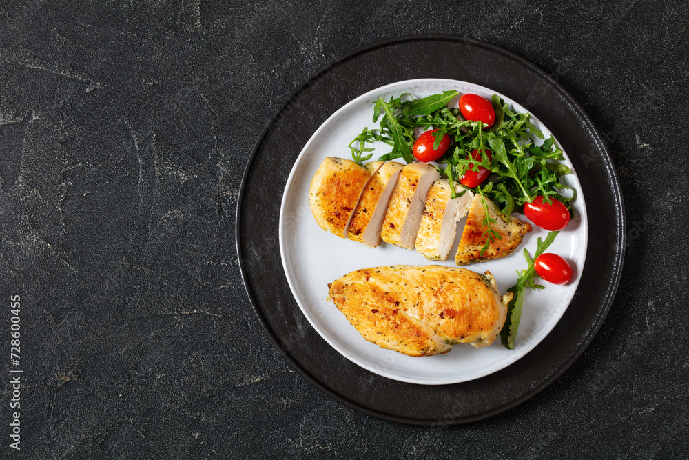 fried chicken breasts with green salad on plate