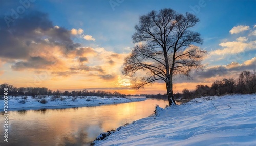 lonely tree on the bank of a winter river with snow covered banks and an evening sky with a beautiful sunset © Wayne