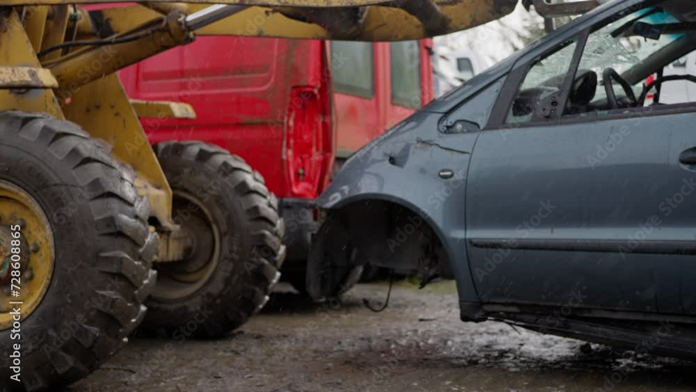 Forklift stacks cars into pile in junk yard close up with fork tidying up scrap vehicles. a Bulldozer moves a broken car through a landfill in rainy weather, slow motion Forklift stacks cars into pile in junk yard close up with fork tidying up scrap vehicles. a Bulldozer moves a broken car through a landfill in rainy weather, slow motion