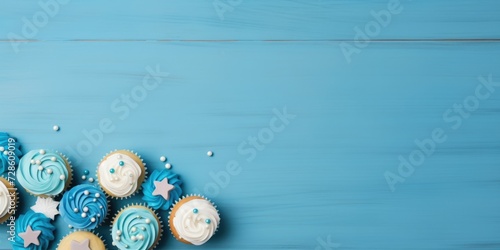 Blue tabletop with cupcakes laid out, room for text.