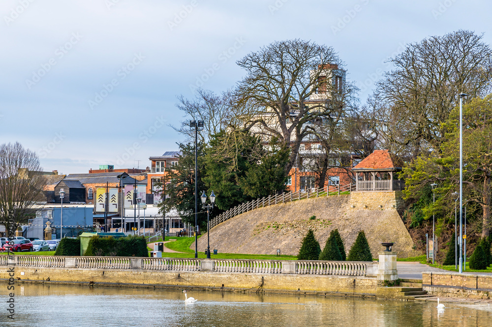 A view across the River Great Ouse towards the Castle Hill in Bedford, UK on a bright sunny day