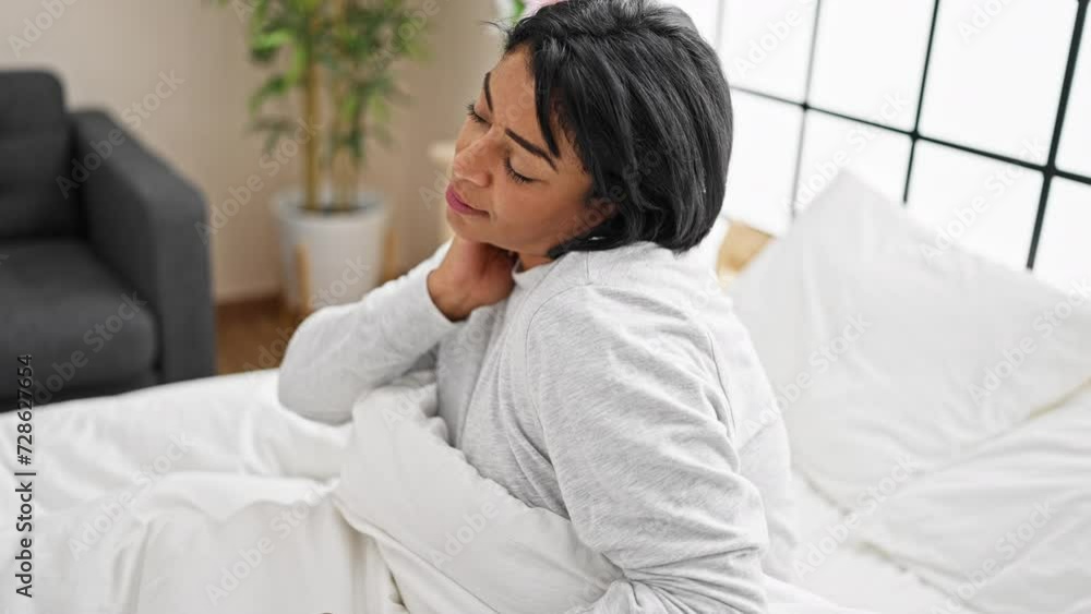 Hispanic woman relaxing in a bright modern bedroom with a comfortable pose and a peaceful expression Hispanic woman relaxing in a bright modern bedroom with a comfortable pose and a peaceful expression