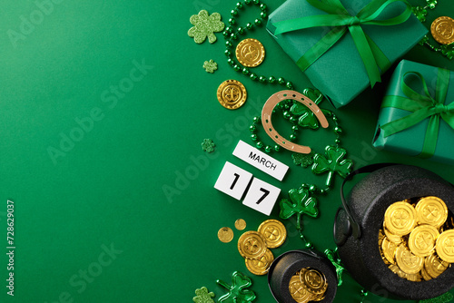 Shamrock surprises: Delightful presents for St. Patrick's. Top view photo of present boxes, pots with coins, cube calendar, horseshoe, trefoils, beads on green background with promo zone
