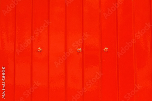 Red metal surface with spots creating textured wall background