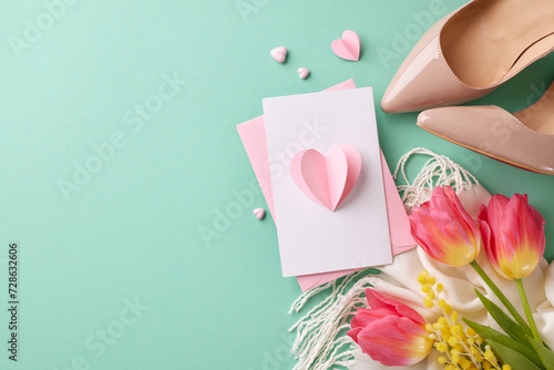 Flourish fiesta: a vibrant celebration of women's achievements. Top view shot of pink envelope with card, cozy scarf, heels, tulips on turquoise background with space for festive text #728632606