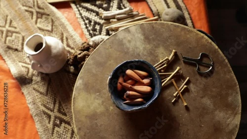 Mapuche culture and tradition. Closeup view of Mapuche aborigines musical instruments. A Trompe and mapuche sacred fruits called piñones, from Araucaria tree, laying over a a drum called Kultrun. photo