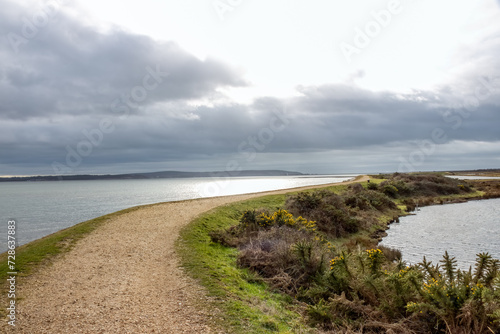 Footpath along The Solent Way trail at Lymington Hampshire England on a stormy winter day