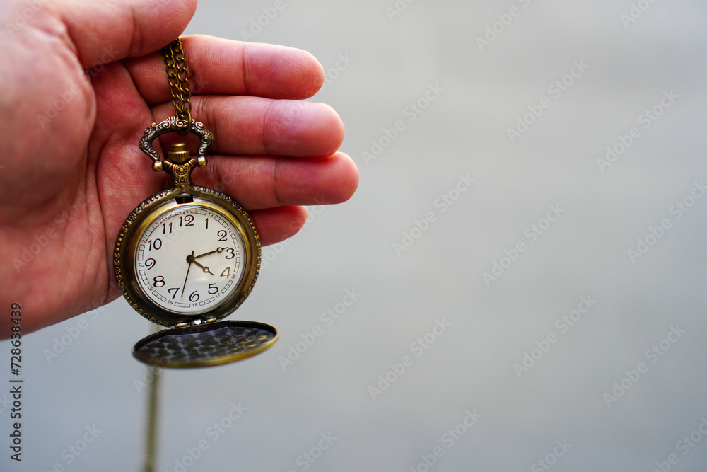 Man's hand holding a pocket watch and blurred background Man's hand holding a pocket watch and blurred background