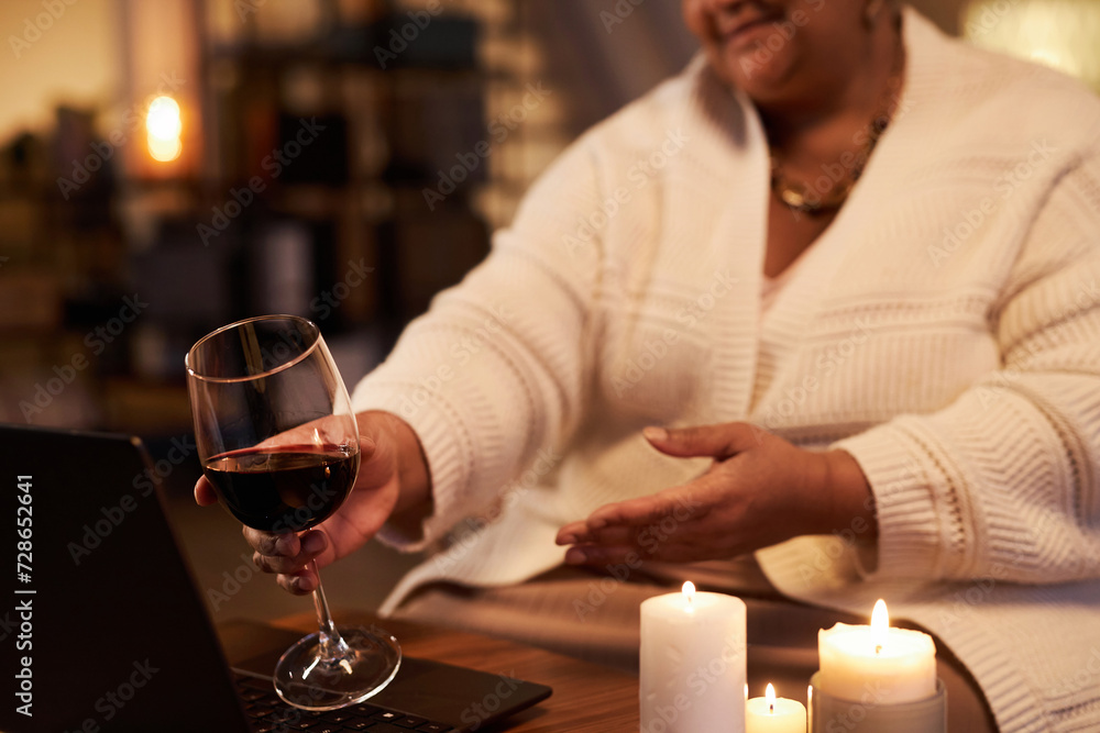 Close up of mature Black woman clinking wine glass to screen while talking by video chat and enjoying online date copy space