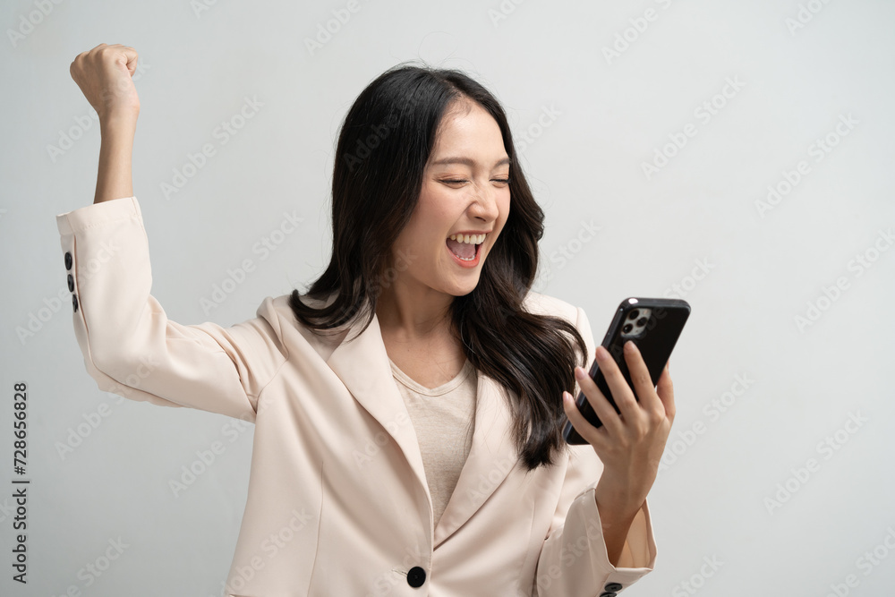 Happy Asian woman holding a smartphone and winning the prize. Happy Asian woman holding a smartphone and winning the prize.