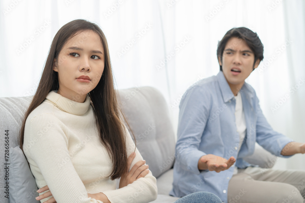 Family problems, Asian women cover her face and sit separately from husband feel disappointed after quarrels at home. Family problems, Asian women cover her face and sit separately from husband feel disappointed after quarrels at home.