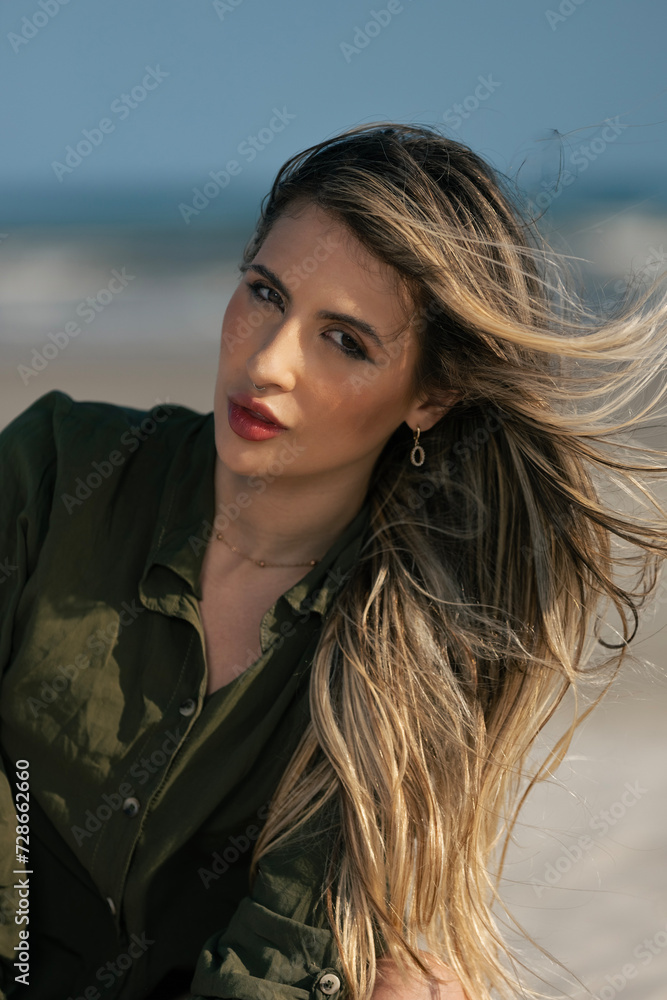 Fototapeta premium young beautiful woman model on the beach in a dress in a fashion photosoot