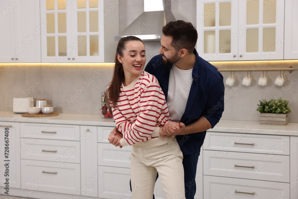 Happy lovely couple dancing together in kitchen Happy lovely couple dancing together in kitchen