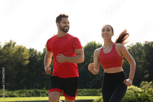 Healthy lifestyle. Happy couple running in park on sunny day