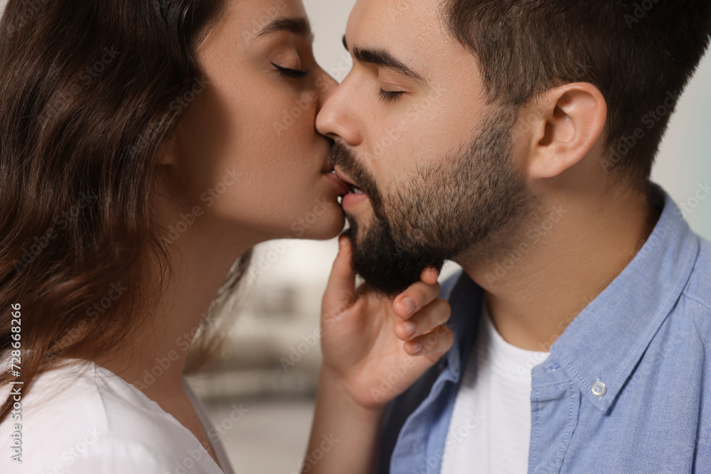 Naklejka premium Love relationship. Passionate young couple kissing indoors, closeup