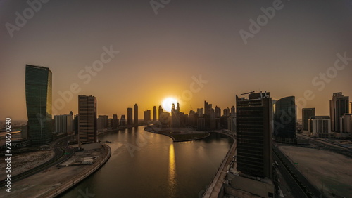 Cityscape skyscrapers of Dubai Business Bay with water canal aerial all day timelapse.