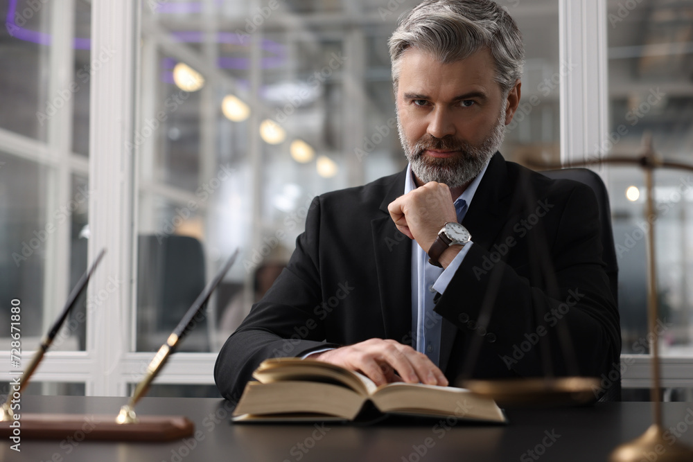 Portrait of confident lawyer at table in office Portrait of confident lawyer at table in office