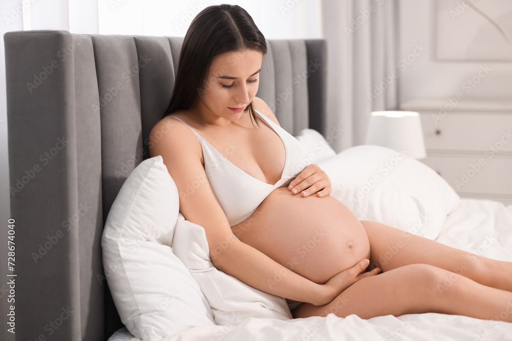 Beautiful pregnant woman in stylish comfortable underwear on bed at home Beautiful pregnant woman in stylish comfortable underwear on bed at home