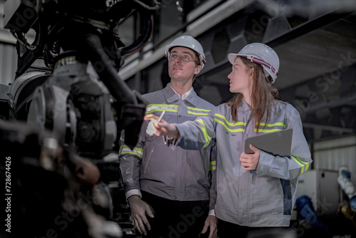 Fotografie Sales manager and factory owner in suits negotiating selling robots used in the factory