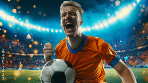 excited soccer player in an orange jersey is holding a soccer ball, celebrating with a stadium in the background © MP Studio