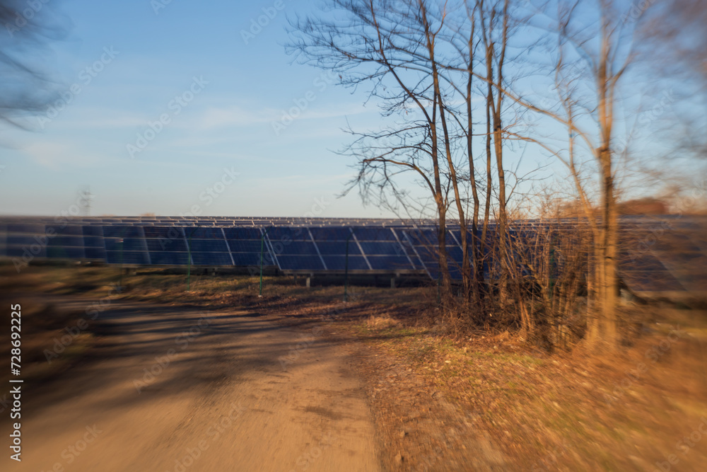 Photovoltaic power plant panels in nature. A dirt road leads around. Photographed with an old lens.