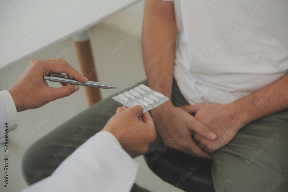Male diseases. Man presses hands to his groin and suffering from pain, panorama, cropped, studio shot Male diseases. Man presses hands to his groin and suffering from pain, panorama, cropped, studio shot