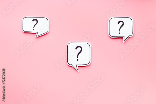 FAQ concept - paper speech bubbles with question mark, top view