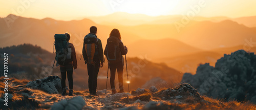 family adventure with backpacks hiking in the mountains at sunset photo