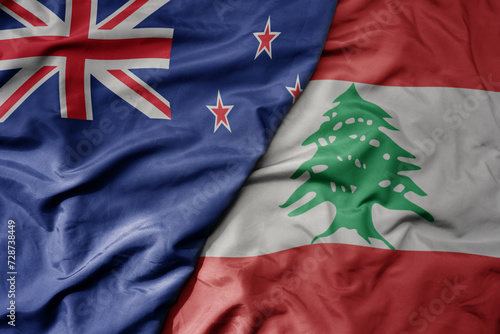 big waving national colorful flag of lebanon and national flag of new zealand . photo