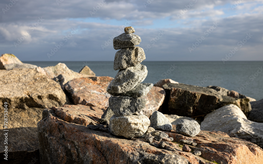 Balance and harmony, Japanese Zen stone garden background. Dark black granite stones on large symbolize concentration and relaxation. Rock Zen Pyramid - Concept of life balance, harmony and meditation