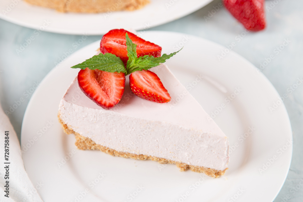 Sweet breakfast, delicious cheesecake with fresh strawberries and mint, homemade recipe without baking, on a blue stone table. Copy space.