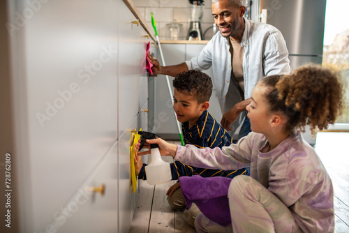 Father and children cleaning the kitchen at home